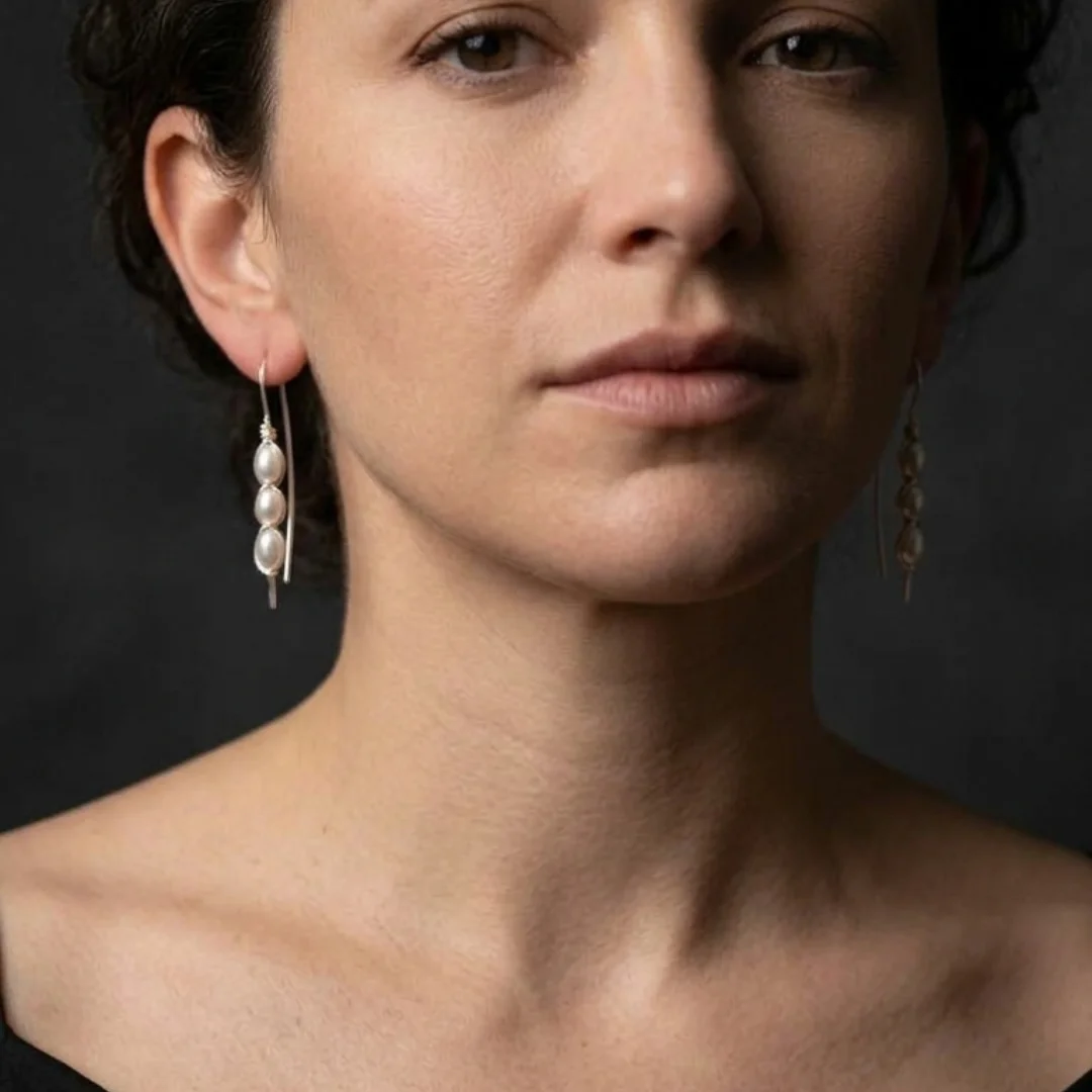 Wire wrapped pearl earrings worn — long marquise drop earring with pearl cage, REPIOR® handmade jewellery England